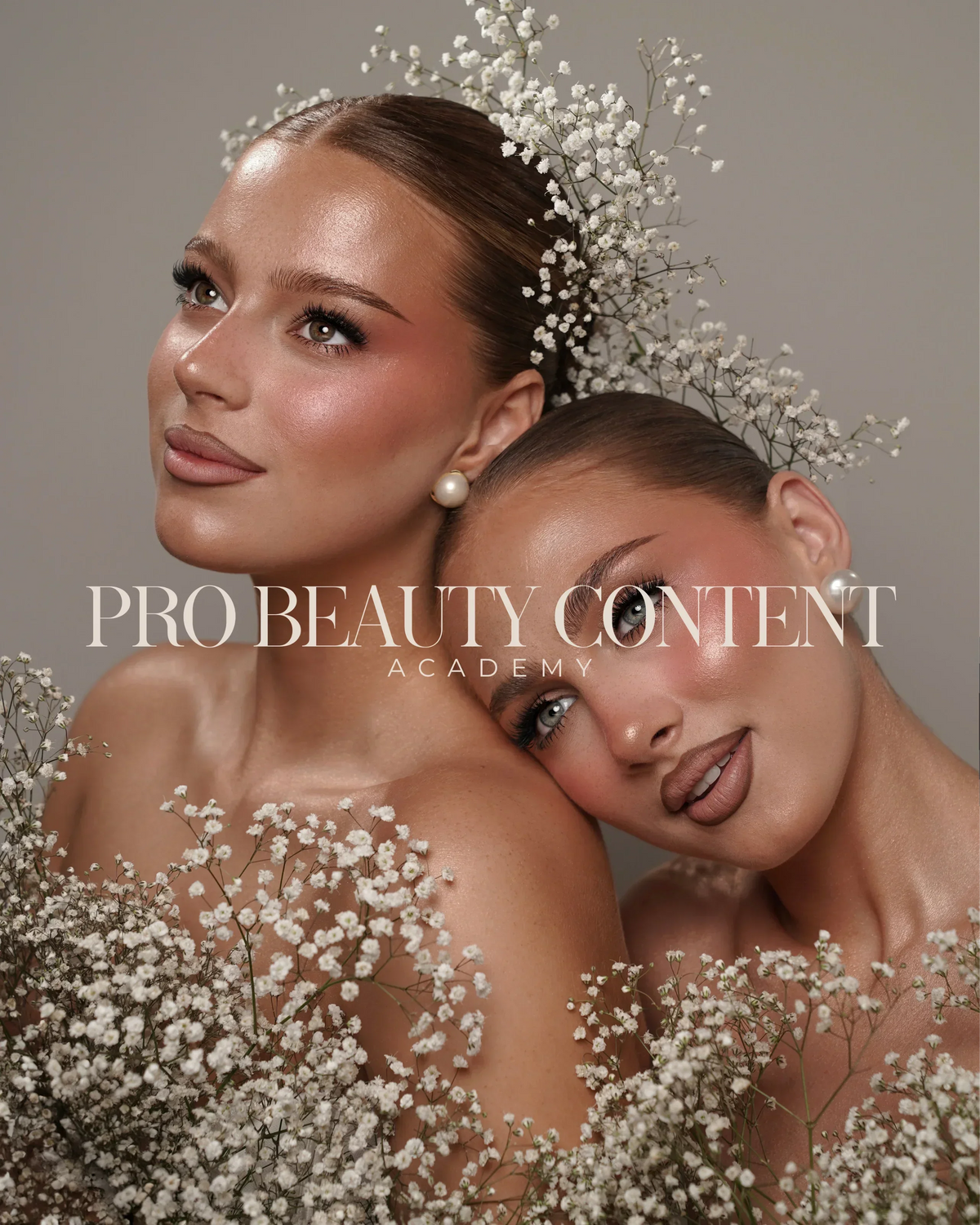 Doua modele cu machiaj luminos, inconjurate de flori albe, intr-un portret pentru Pro Beauty Content Academy.