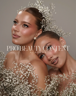 Doua modele cu machiaj luminos, inconjurate de flori albe, intr-un portret pentru Pro Beauty Content Academy.